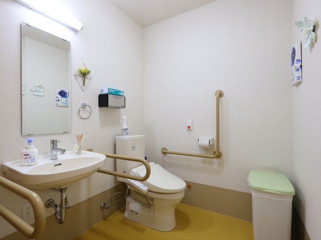 バリアフリー対応トイレ トイレ 安全な手すりが設置された清潔なトイレ空間です。利用者の快適性を考慮し、細やかな配慮が行き届いています。