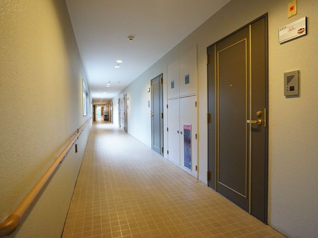 廊下の手すりと部屋の扉 廊下 手すりが付いた広々とした廊下です。明るく清潔感があり、安心して歩ける環境が整っています。