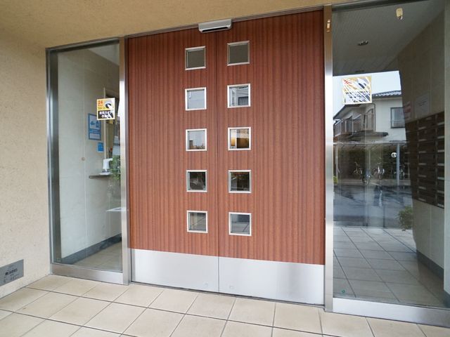 茶色のモダンなエントランス 入り口 明るく開放感あるエントランスです。来訪者が快適にお出迎えできるデザインになっています。