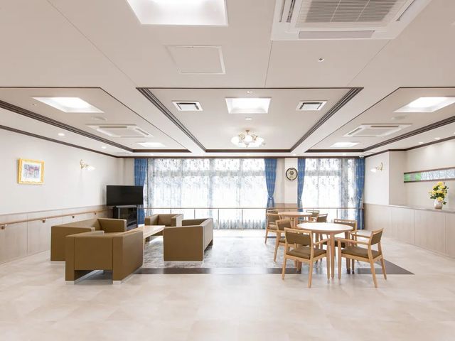 明るい談話スペース リビング   大きな窓から光が入る、ゆったりしたリビングです。ソファ席とテーブル席があり、くつろぎや会話の場として使いやすそうです。