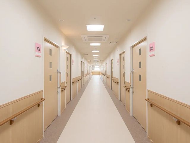 明るい廊下 廊下   手すりが両側に設置された、見通しのよいまっすぐな廊下です。居室の出入りがしやすい落ち着いたつくりです。