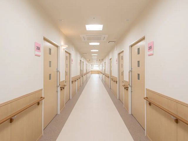 明るい廊下 廊下   手すりが両側に設置された、見通しのよいまっすぐな廊下です。居室の出入りがしやすい落ち着いたつくりです。