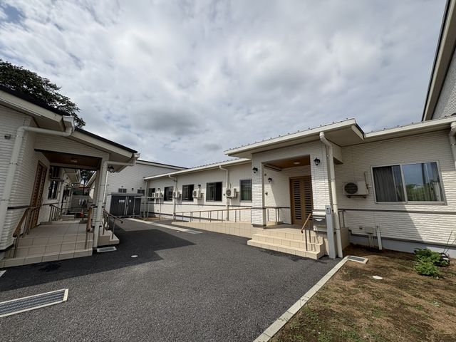 白い建物の外観 外観 シンプルな白い建物が並ぶ様子です。木製の手すりは、入居者の方の移動を助けます。