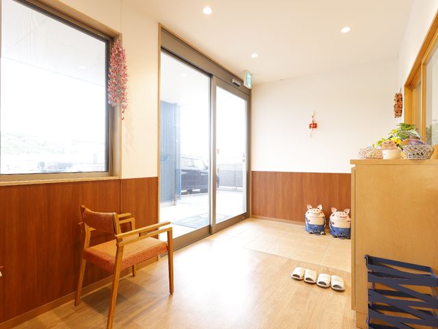 入口付近の優しい雰囲気 玄関 広々としたエントランスには、落ち着いた色合いの家具が配置され、訪れる人を温かく迎えます。明るい日差しも心地よいこの空間で、のんびりとした時間を楽しめそうです。