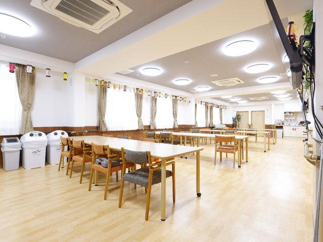 広々とした明るい食堂 共有スペース ゆったりと配置されたテーブルと椅子が並び、窓から自然光が差し込む居心地の良い食堂です。快適な空間でのお食事や交流をお楽しみいただけます。