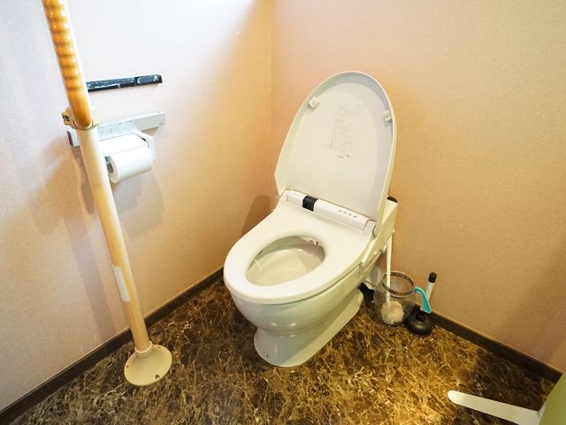 バリアフリートイレの一角 トイレ 手すり付きのトイレは、安全かつ自立した日常生活をサポートします。清潔感溢れる空間で、快適な時間をお過ごしいただけます。