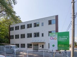 白い建物の外観と緑の看板