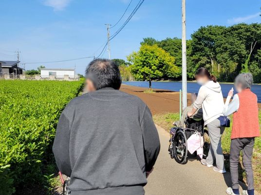 散歩中の利用者とスタッフ
