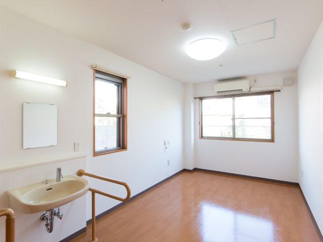 明るい洋室のベース 居室 手すりが備わった清潔感のある居室の様子です。窓からの自然光が心地よい空間を演出しています。