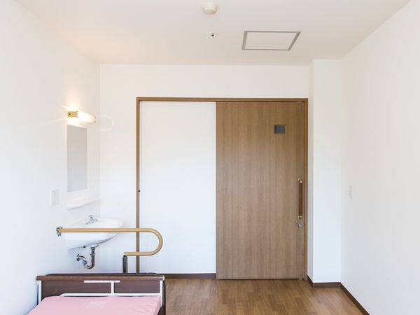 洋室のベッドと洗面台
