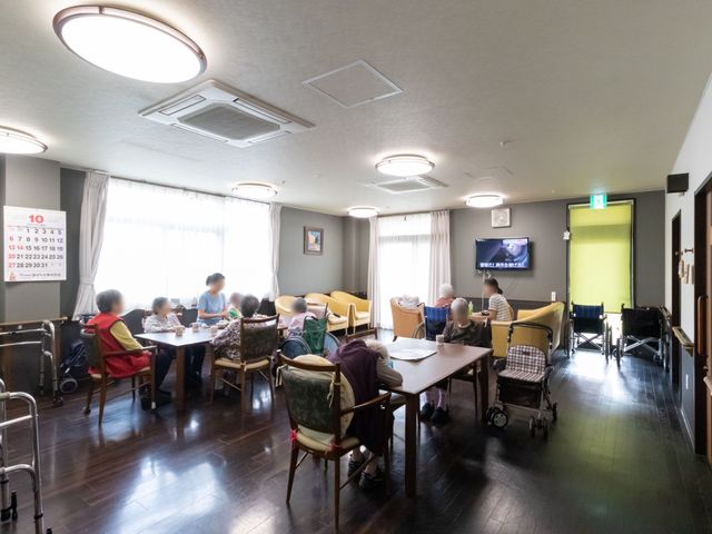 共用スペースの日常風景 共有スペース 居心地の良いダイニングルームで、利用者の方々が穏やかな時間を過ごされています。適度な広さと明るい光が心地よい空間を演出しております。