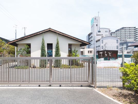 白い建物と入口の鉄柵