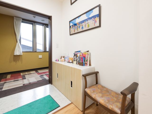 暖かみのある廊下 玄関 ゆったりとしたベンチで一息つける廊下の一角です。壁に掛けられた絵画が空間に彩りを加えています。