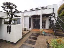 白壁の建物と植栽のエントランス
