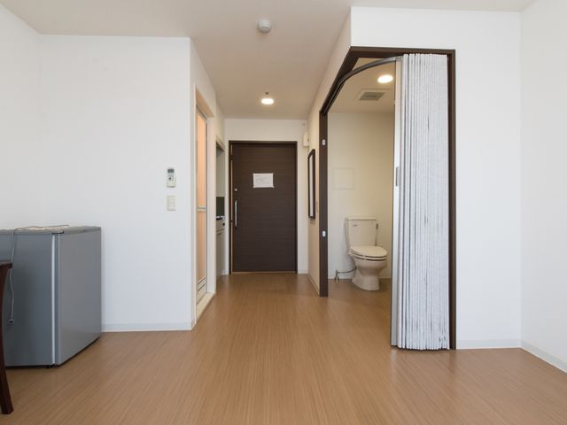 明るい居室の一角 居室 ゆったりとした床の空間には、日常生活に必要な備品が整っており、清潔感のあふれるトイレも備え付けられています。