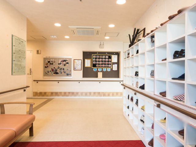 エントランスと靴箱 玄関 明るく開放的なエントランスです。靴箱が整然と並び、居心地の良い待合スペースも備わっています。