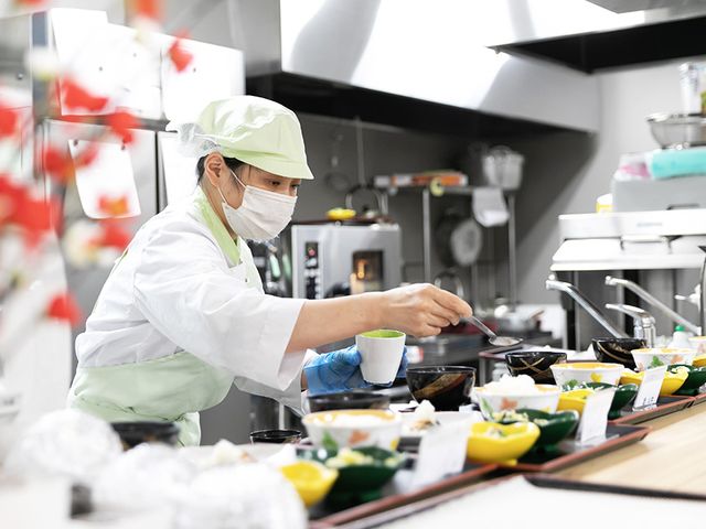 調理中のスタッフのキッチン キッチン 豊富な料理を丁寧に準備する様子が見られます。清潔な環境で働くことができます。