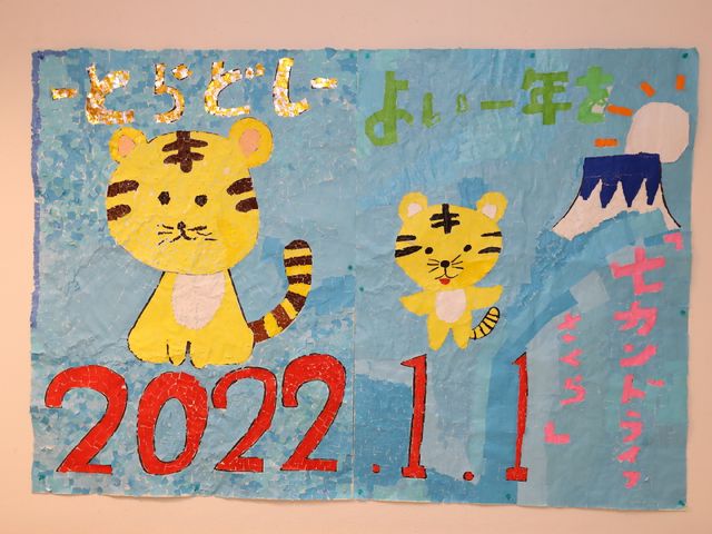 壁に掛けられた虎の絵画 共有スペース 手作り感溢れる壁掛けアートが施された空間です。色鮮やかで温もりを感じさせる作品が訪れる人々の心を和ませます。
