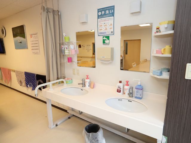 清潔な洗面所設備 洗面台 十分なスペースの洗面台で、日々の清掃が行き届いています。利用者の方々の衛生管理に配慮した環境が整っております。