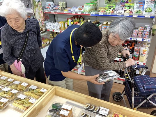 買い物する高齢者と職員  