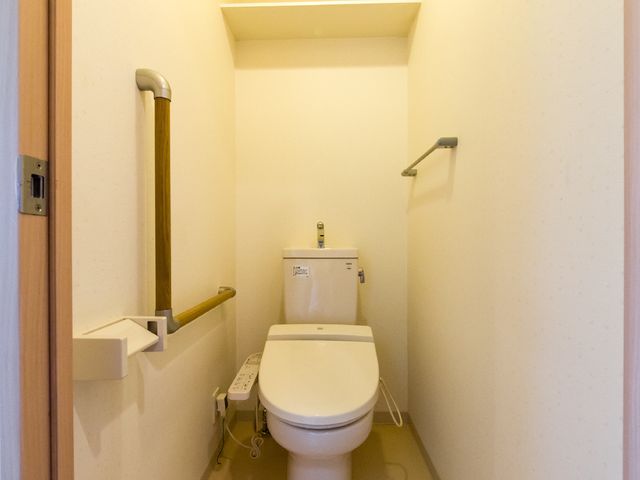 バリアフリートイレ トイレ 手すりが設置された清潔感のあるトイレです。安全を配慮した設計で、快適な使用が可能です。