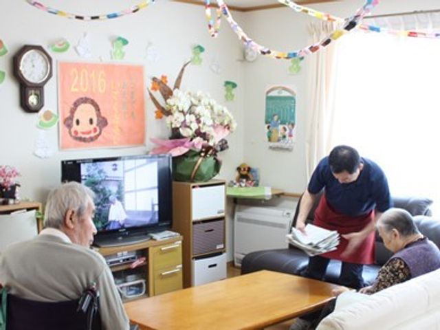 和やかリビングシーン 共有スペース スタッフが笑顔でサポートし、利用者の方々との交流を育む暖かな空間です。心地よい共有スペースでのふれあいが楽しめる環境をご体感ください。