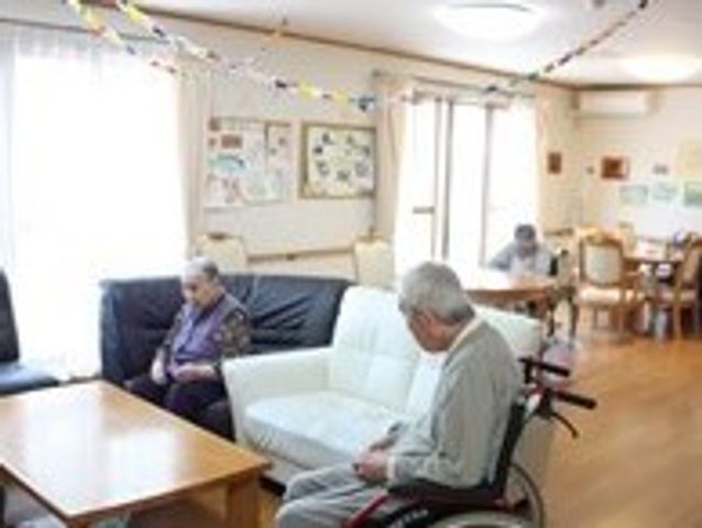 明るい共有リビング空間 共有スペース 心地よい光が差し込むリビングです。利用者の方がそれぞれリラックスしたひとときを過ごされています。