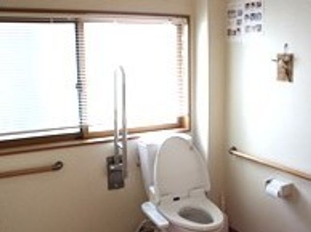 バリアフリーのトイレ トイレ すり支え棒付きの機能的なトイレです。安全かつ快適な使い心地を実現し、利用者の自立を支援しています。