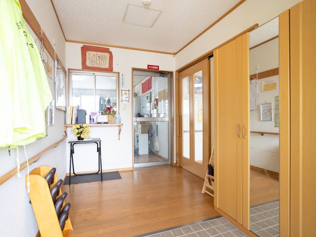 温かみのあるエントランス エントランス 木目調の開放的なエントランスです。木製の椅子が設置され、落ち着いた待合スペースを提供しています。