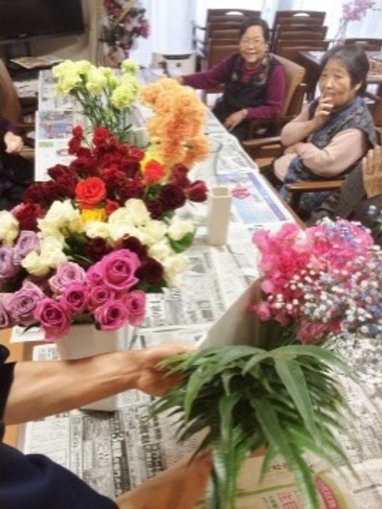 花束を手にする人々