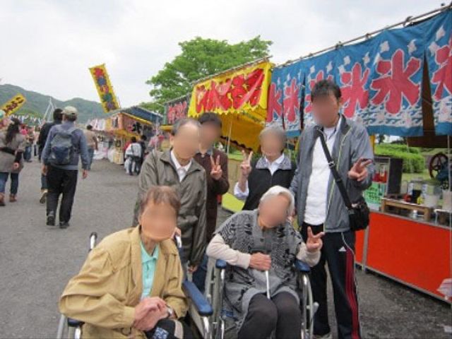 屋外イベント参加の高齢者 お祭り 明るい雰囲気の中でイベントを楽しむ高齢者の方々です。多彩な活動が支援される、活気に満ちた施設でしょう。