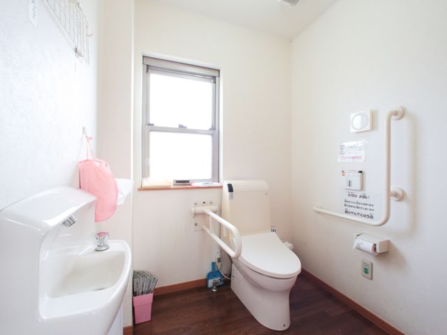 バリアフリーのトイレ空間 トイレ 手すり付きで安全に配慮されたトイレです。清潔感のある室内で利用者の自立を支援します。