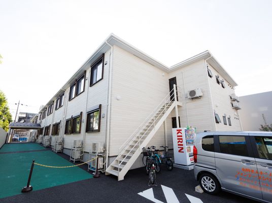 白い建物と駐車場の外観
