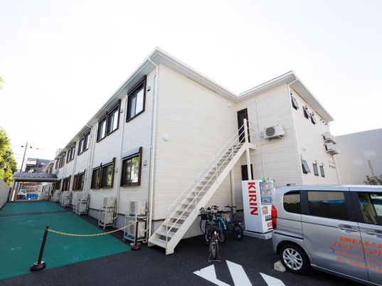 白い建物と駐車場の外観