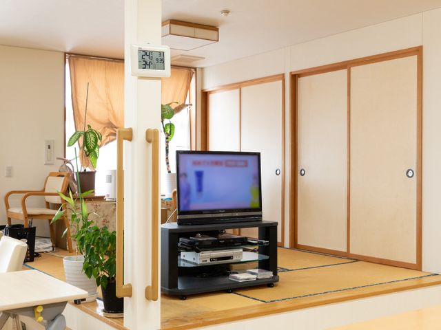和室に設置されたテレビ 共用スペース 心地よいリビングでは、共有のテレビで映画や番組を楽しめる設備が整っており、リラックスした時間を提供しています。