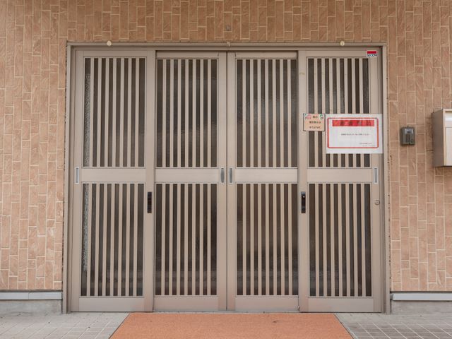 広々としたエントランスの扉 外観 落ち着いた色合いの出入口は、すべての方が安心して利用できるように設計されています。いつでも安全で快適な出迎えが待っています。
