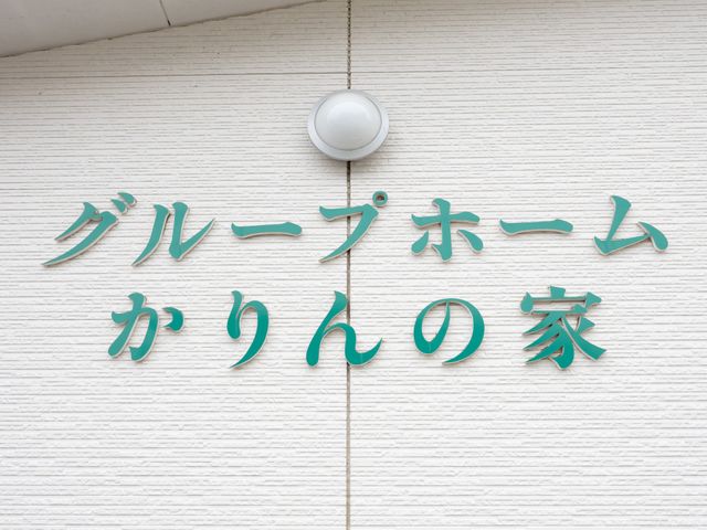 グループホームの看板 看板   白い外壁に緑色の文字が映える看板です。親しみやすい雰囲気があり、施設の入口をわかりやすく示しています。