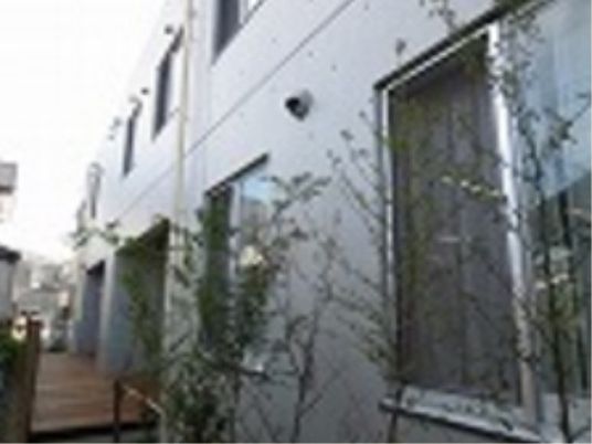 白い外壁の建物と緑
