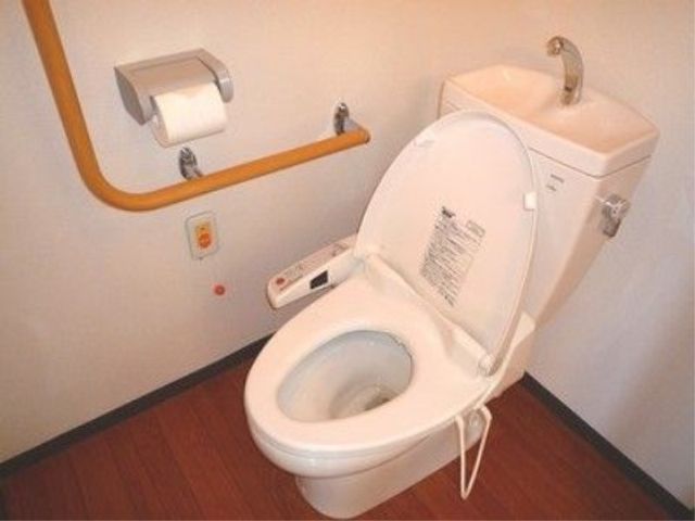 バリアフリー設計のトイレ トイレ 手すり完備した清潔なトイレスペースです。利用者の安全と自立支援を考慮し、快適な環境が整っています。