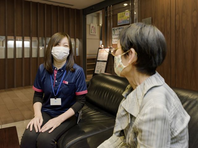 明るい笑顔の共有時間 ケア 安らかなひとときを過ごす利用者様とスタッフの姿です。穏やかな自然の中で、温かい対話が生まれています。
