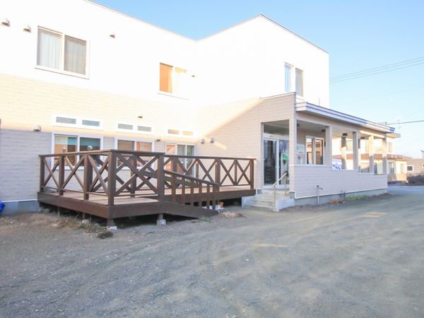 白壁の建物と木製デッキ