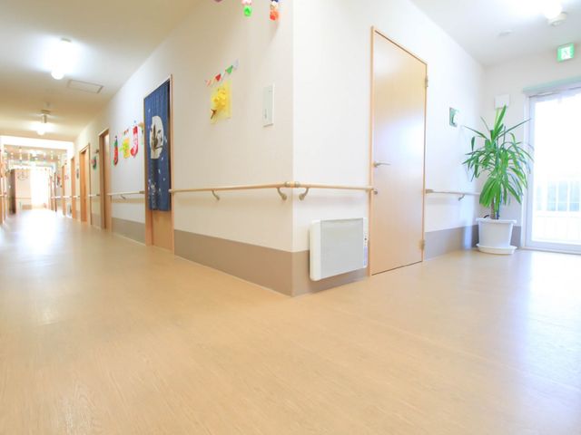 手すり付きの明るい廊下 廊下 壁に手すりが設けられた明るい廊下は、安全に移動するための工夫がされており、快適な勤務環境を提供しています。