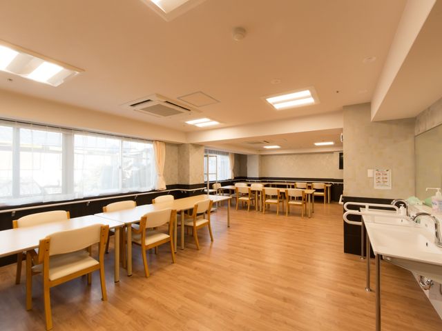 広々とした明るい食堂 食堂 床が木目調で落ち着いた色合いの食堂は、ゆとりのある空間でお食事を楽しめます。手すり付きの洗面台もあり、安心してご利用いただけます。
