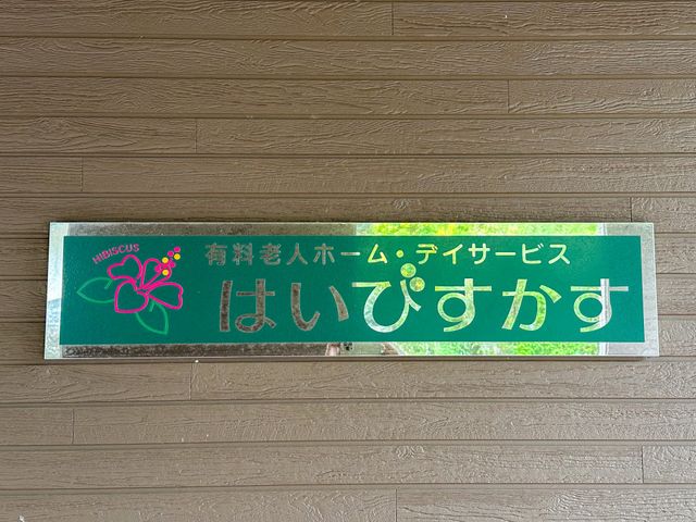 施設名が記された緑色の看板 看板 温もりあるデザインの看板が、皆様の新しい生活の場を暖かくお迎えします。