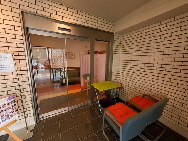 ゆったりとしたエントランス エントランス 落ち着いた色合いのエントランスでは、柔らかな光が心地よく、来訪者を温かく迎えてくれます。チェアでひと息つくこともでき、安らぎの空間が広がっています。