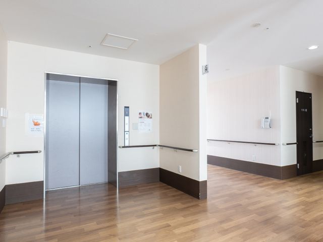 広々とした廊下とエレベーター エレベーター 手すりが備えられた明るく広い廊下です。ここを通じて各部屋や施設の共有スペースへと移動できます。