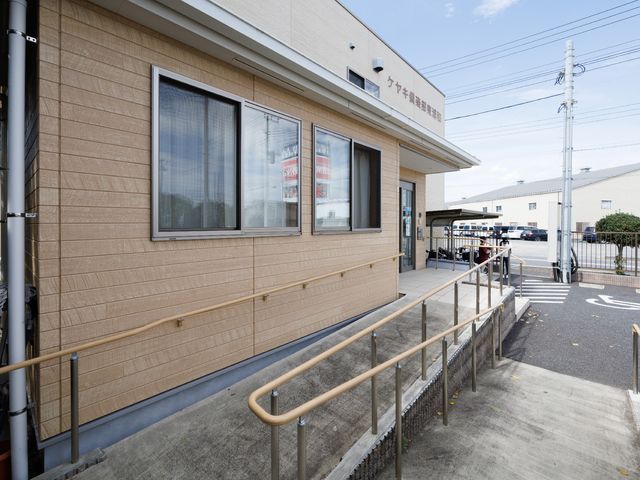 バリアフリー構造の建物外観 玄関 ゆったりとしたスロープが設けられ、手すりのついた明るい建物の外観です。安全かつ快適な移動が配慮された環境をご覧いただけます。