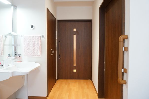 洗面台と木製ドアの廊下