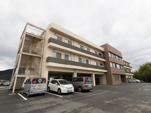 広々とした駐車場のある建物 外観 清潔感のある外観の建物で、スタッフとして快適な環境でのお仕事が望めます。周りの緑も心地よい空間を作り出しています。