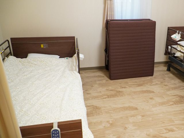 整った居室の様子 居室 ゆとりのあるベッドスペースを備えた居室で、清潔感溢れる落ち着いた雰囲気が伺えます。安心して日々を過ごせる設備が整っています。